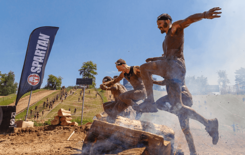 Spartan Race men jumping over obstacle