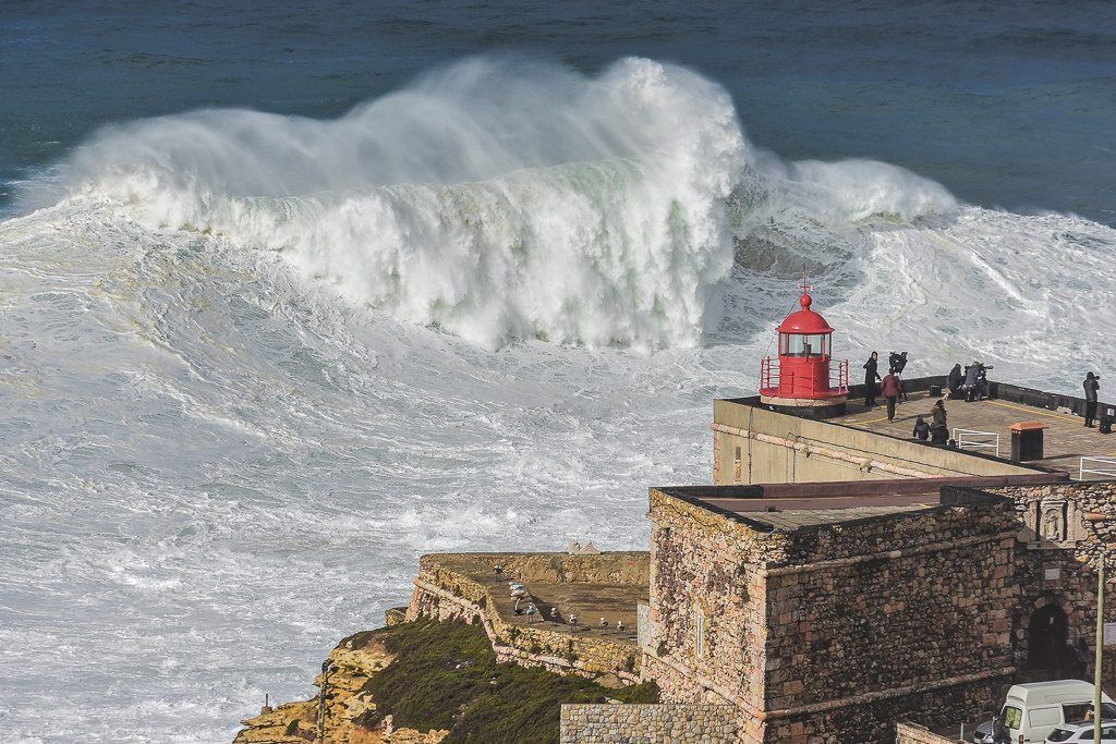 Waves crashing into Nazaré lighthouse